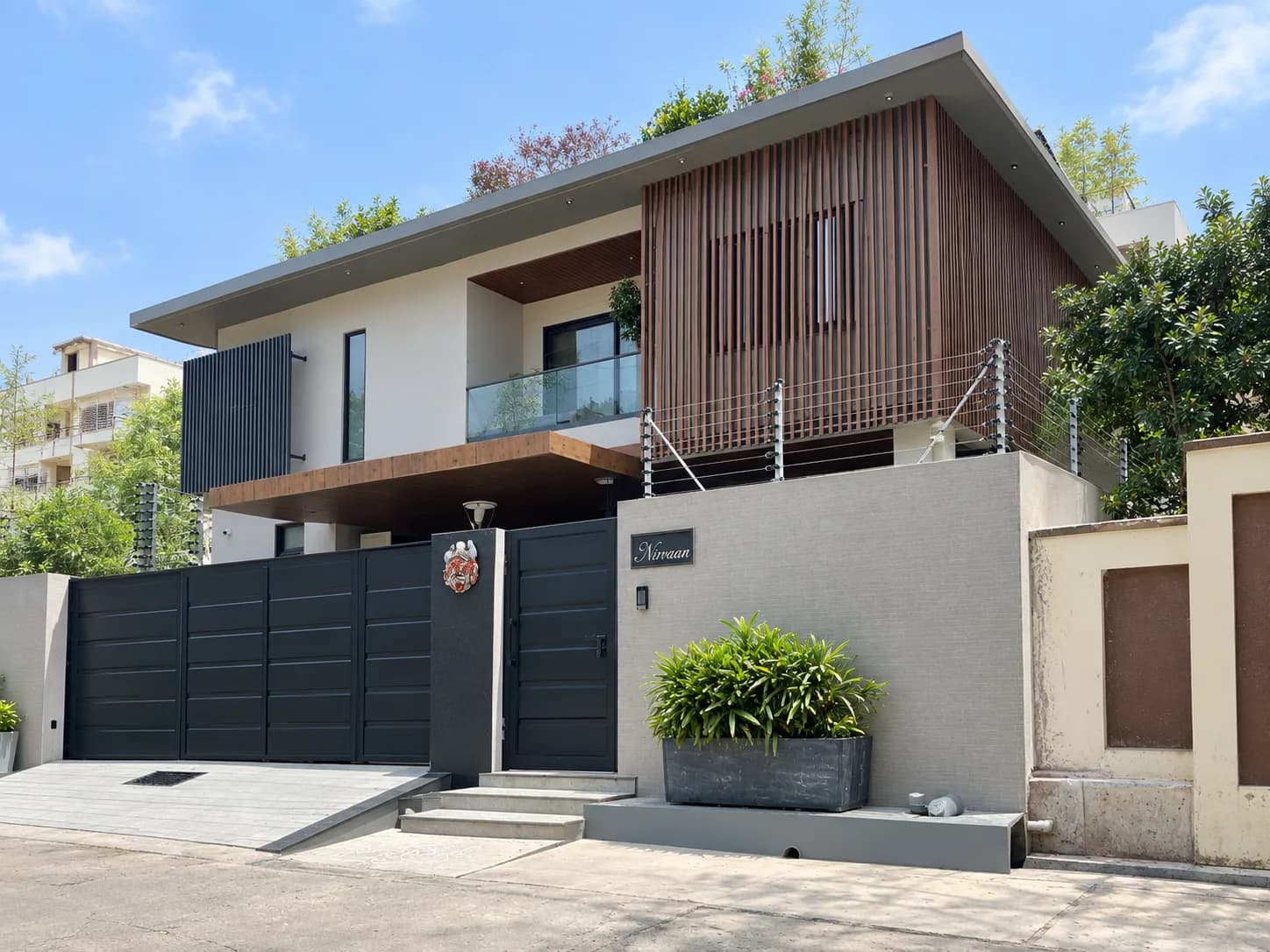 Connected Villa with timber facade, black entrance gates and perimeter security fencing