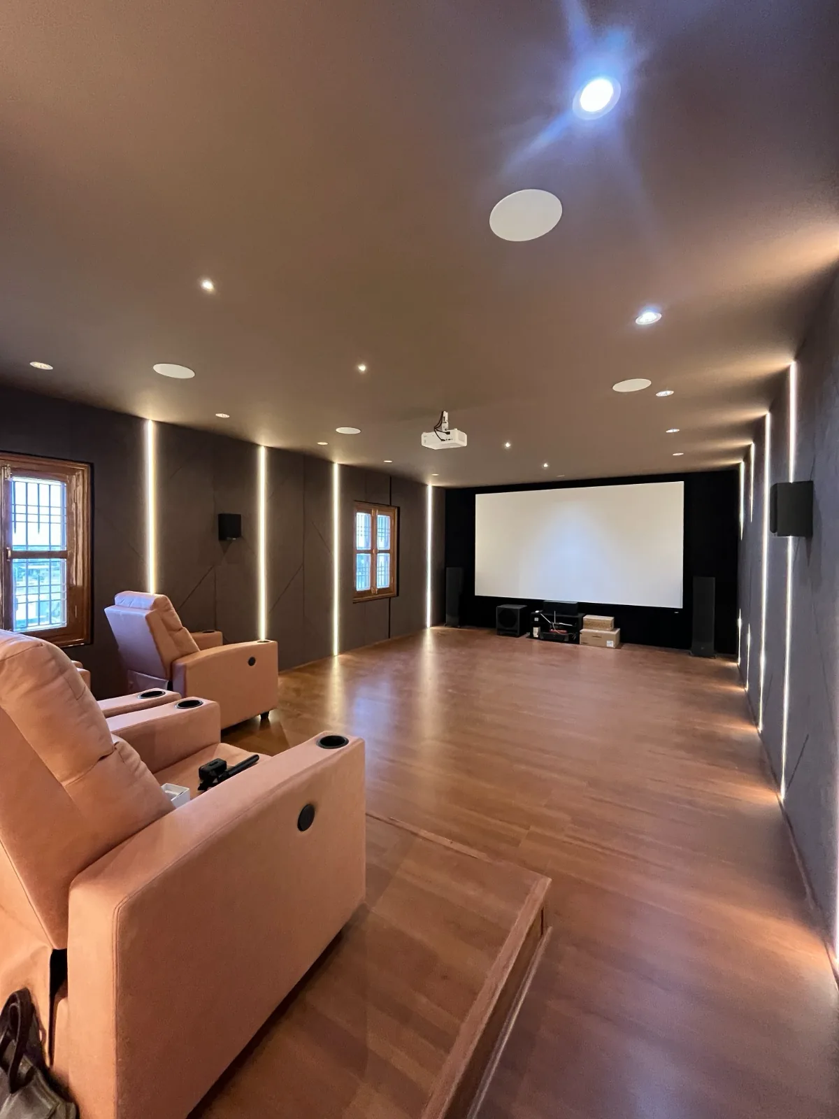 Home theatre with recliners, ceiling projector, surround speakers and illuminated acoustic walls